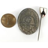 German militaria comprising a veteran enamel stick pin, wounds badge and button