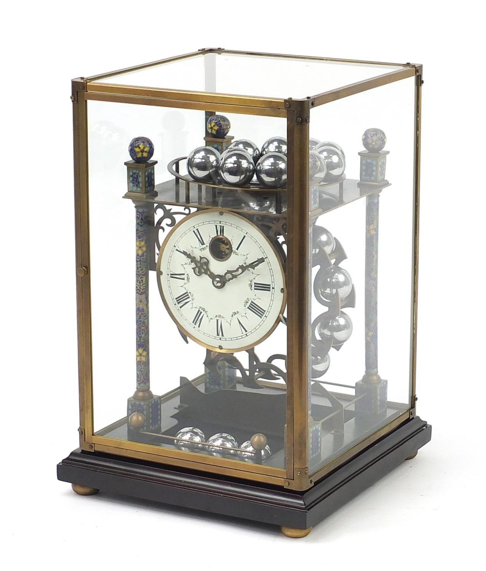 Champlevé enamel rolling ball clock with enamel dial having Roman numerals and glass display case,