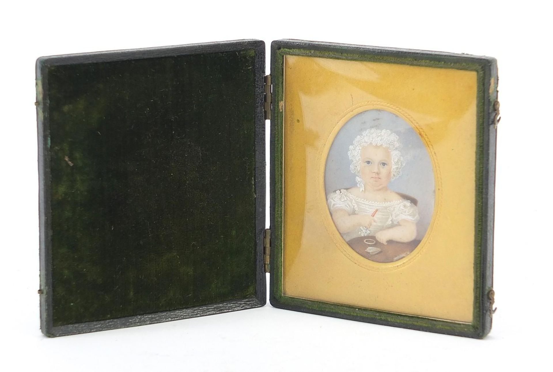 19th century oval hand painted portrait miniature of a young girl holding a rattle, housed in a