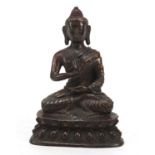 Chino-Tibetan partially gilt bronze figure of seated Buddha with remnants of red paint 15.5cm high