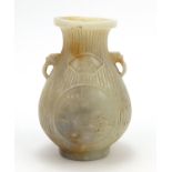 Chinese white and russet jade vase with handles carved with panels of landscape, 19.5cm high