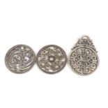 Two Chinese silver coloured metal dragon roundels and an archaic style pendant, the largest 11cm