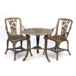 Gold flecked plastic garden table and two chairs, the table 65cm high x 68cm in diameter