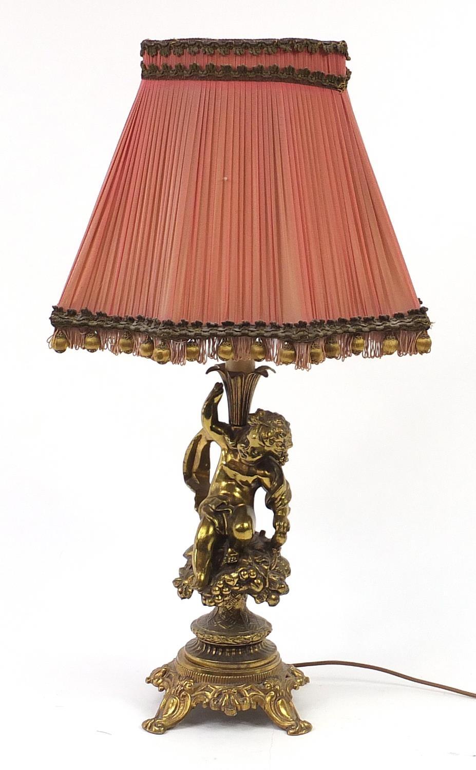 Ornate gilt metal Putti design table lamp with silk lined shade, 71cm high