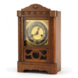 Carved oak mantle clock with silvered chapter ring having Roman numerals, 40cm high :