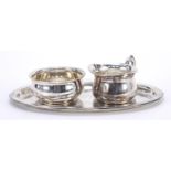 German silver milk jug and sugar bowl on tray, impressed W T B to the base, the tray 24cm wide,