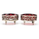 Pair of antique silver open table salts with ruby glass liners, indistinct marks to the base, 8.