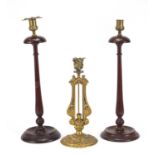 Elkington & Co gilt metal classical candlestick and pair of turned mahogany candlesticks, the