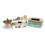 Sundry items arranged in a vintage suitcase including silver plated cutlery, enamel chamber stick,
