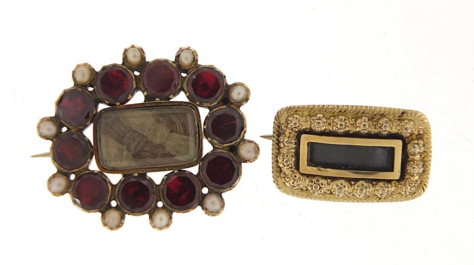 Two Georgian gold coloured metal mourning brooches including one set with garnets and seed pearls,