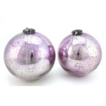 Two large Victorian mirrored mauve glass witches balls, the largest 25cm in diameter :
