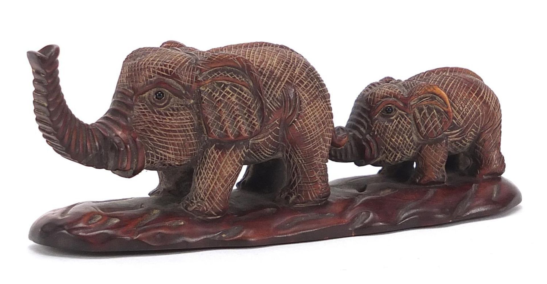 Japanese carved wood okimono of two elephants, inset mother of pearl plaque with character marks