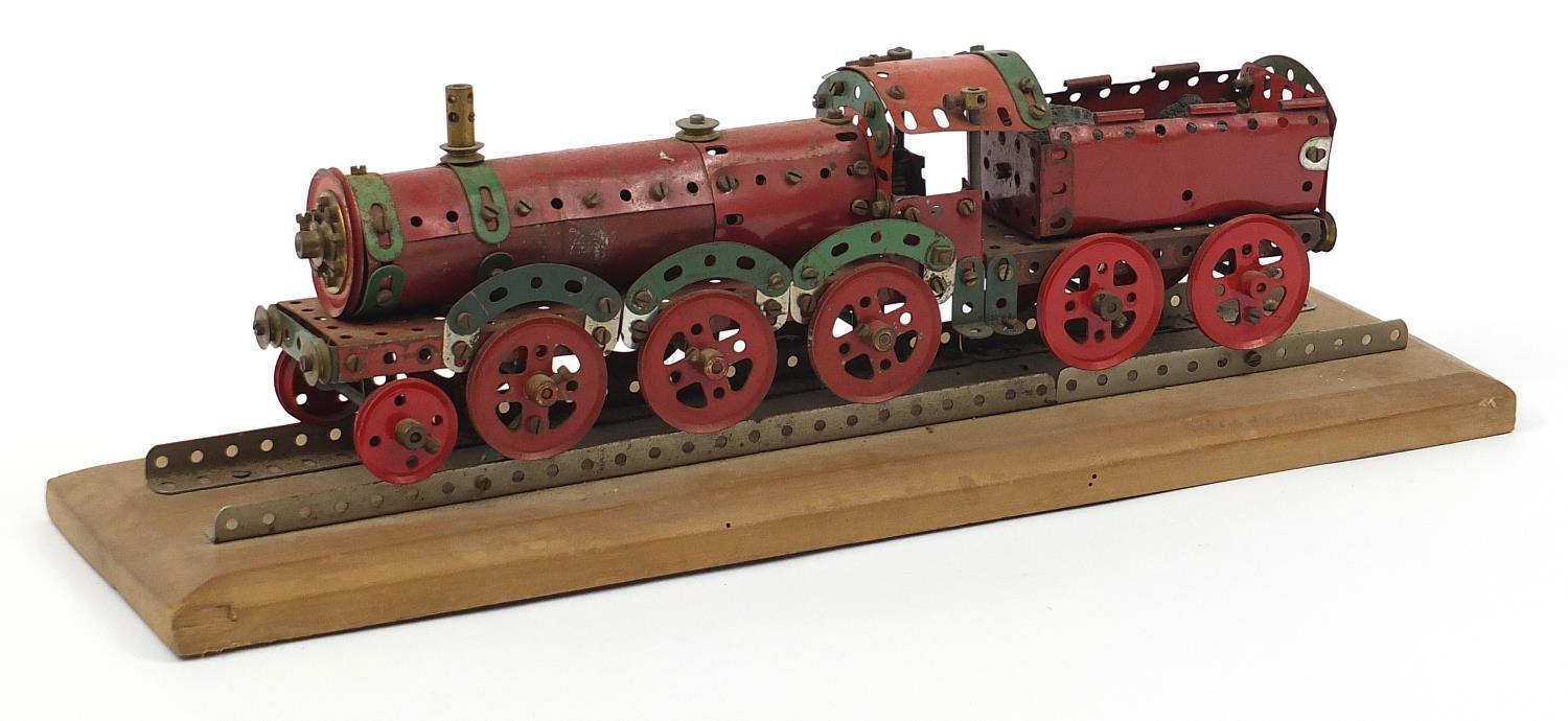 Vintage Meccano scratch built locomotive raised on a rectangular wood plinth base, 63cm wide :