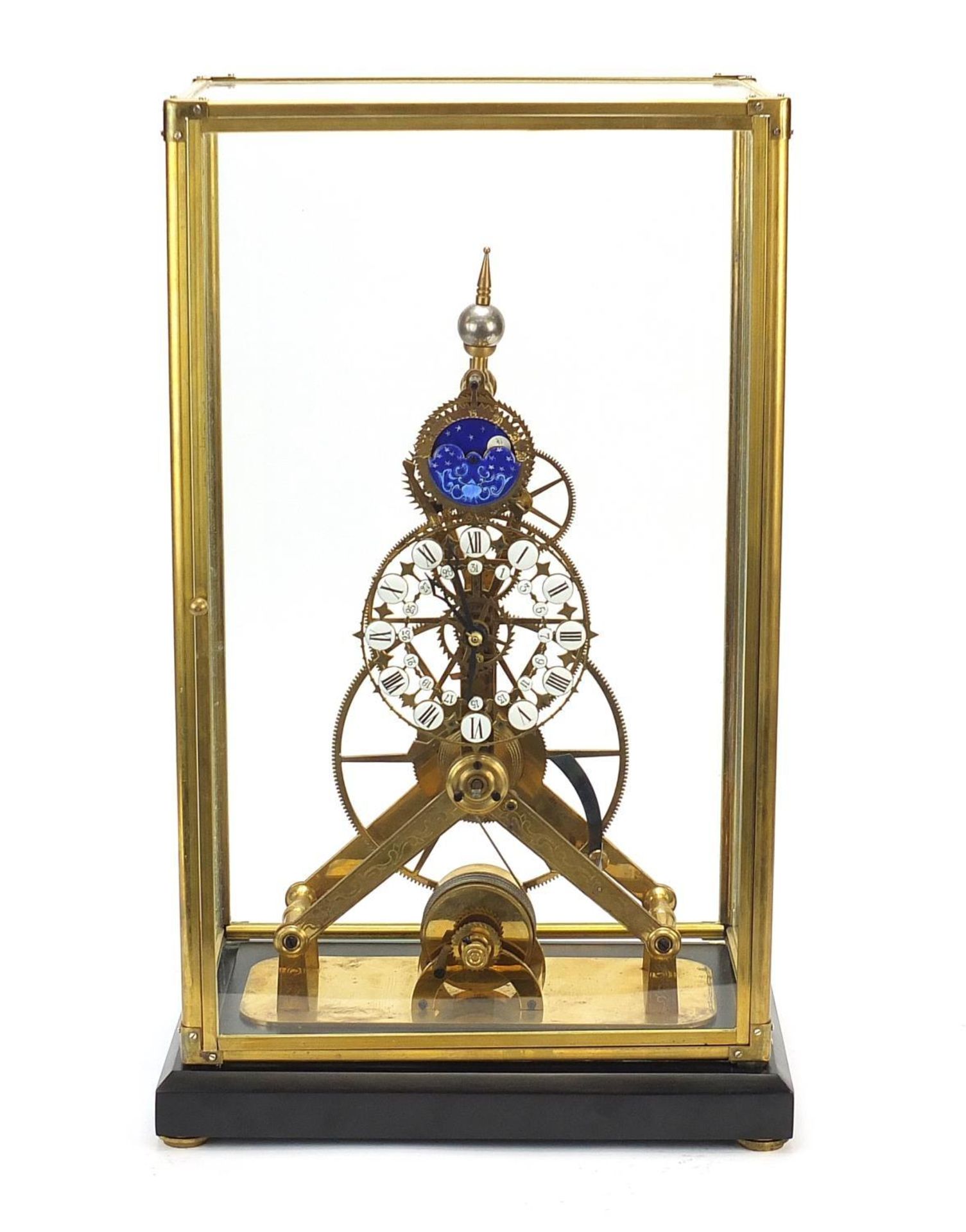 Gothic style brass skeleton clock with moon face dial and glass display case, with key and pendulum,