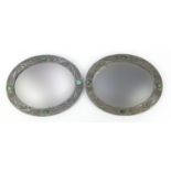 Manner of Liberty & Co, pair of Arts & Crafts oval wall mirrors with embossed pewter mounts and