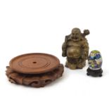 Chinese objects including a bronzed Buddha, cloisonné egg and carved hardwood stand, the largest