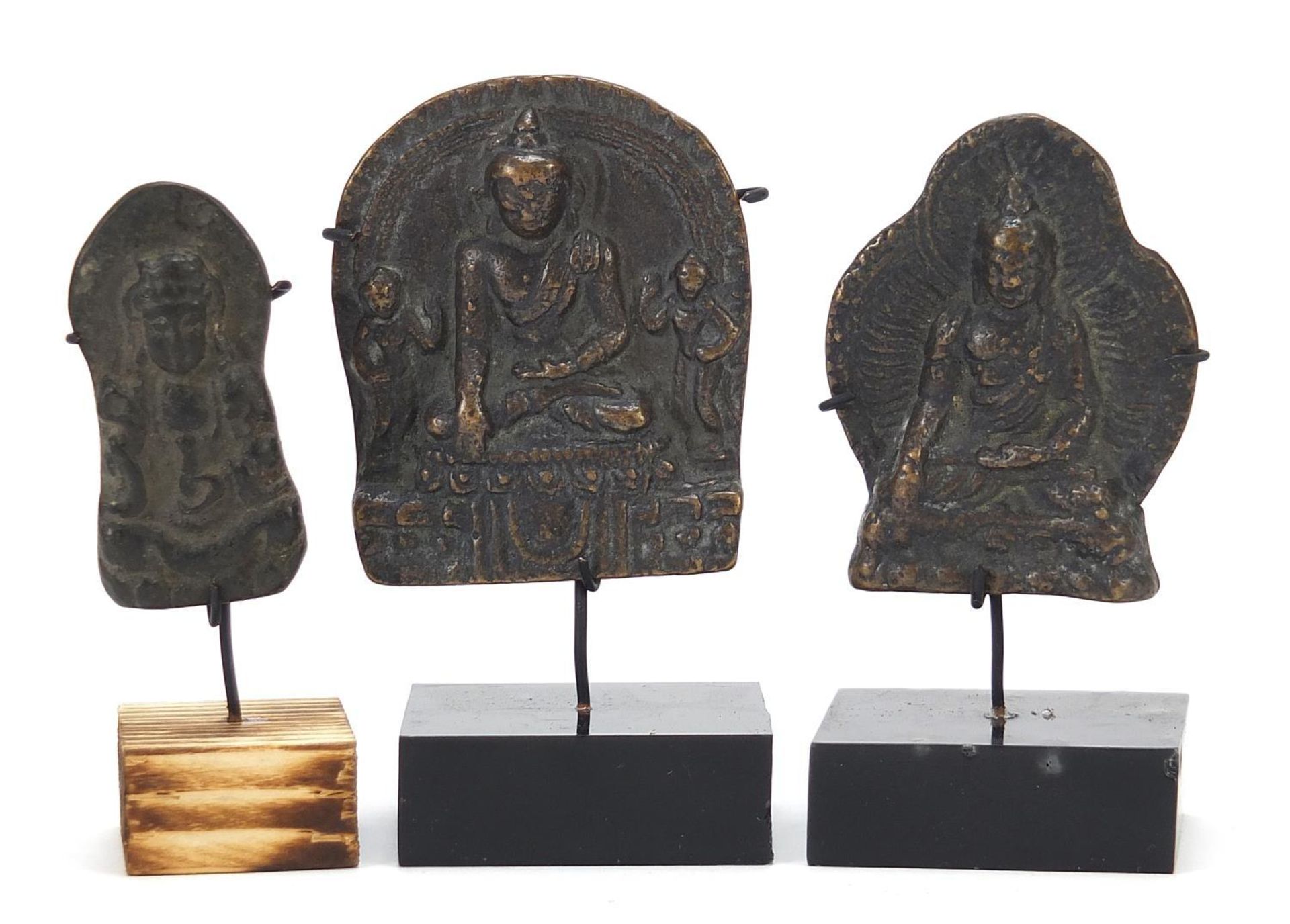 Three Nepalese patinated bronze plaques of Buddha with display stands, the largest 11cm high :