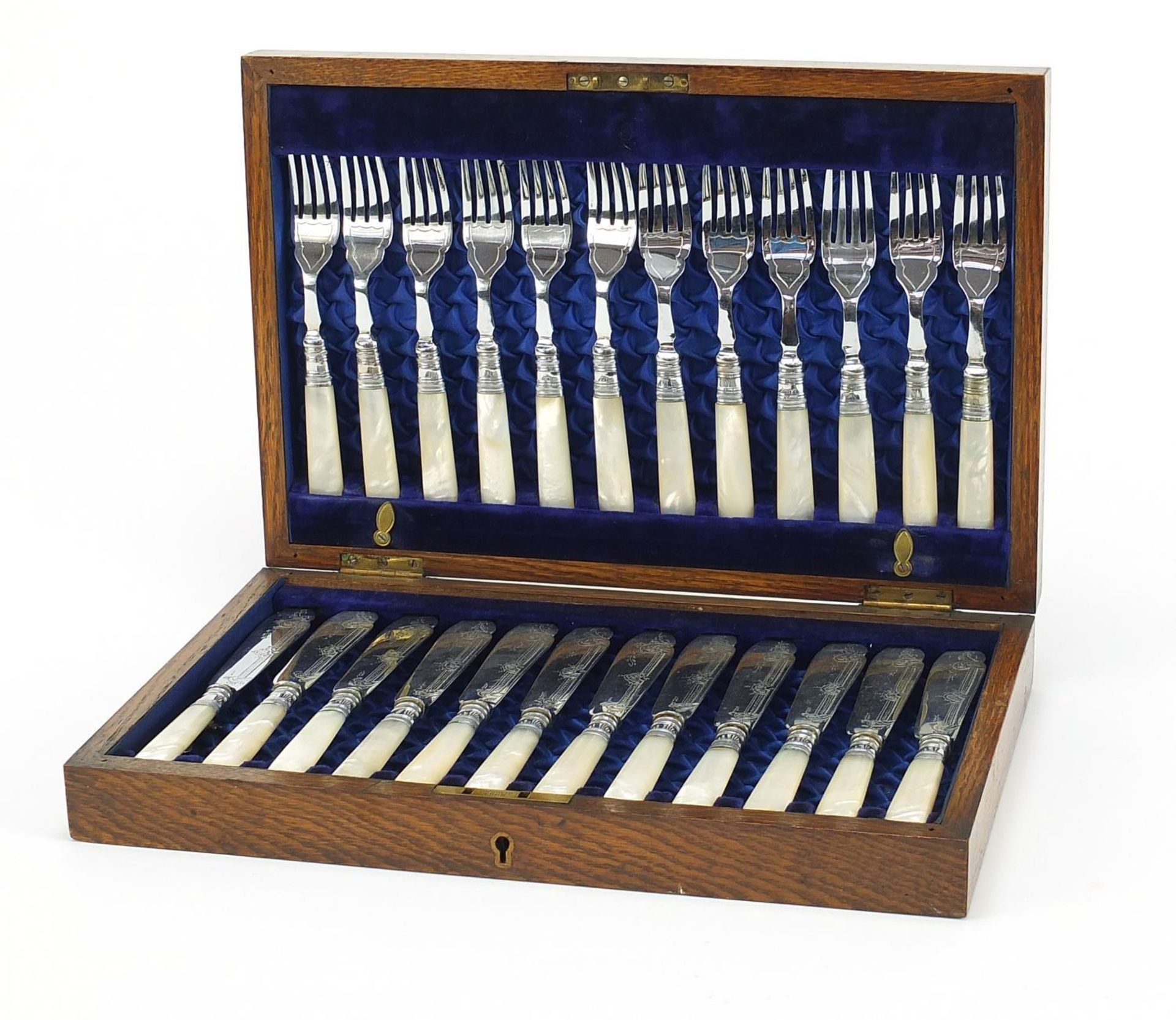 Oak twelve place canteen of silver plated fish knives and forks with mother of pearl handles, the