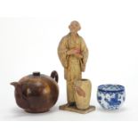 Oriental objects including a carved wood teapot and pottery figure of a man holding a peach, the