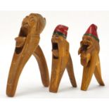 Three pairs of Black Forest style carved wood nutcrackers, the largest 23.5cm in length :For Further