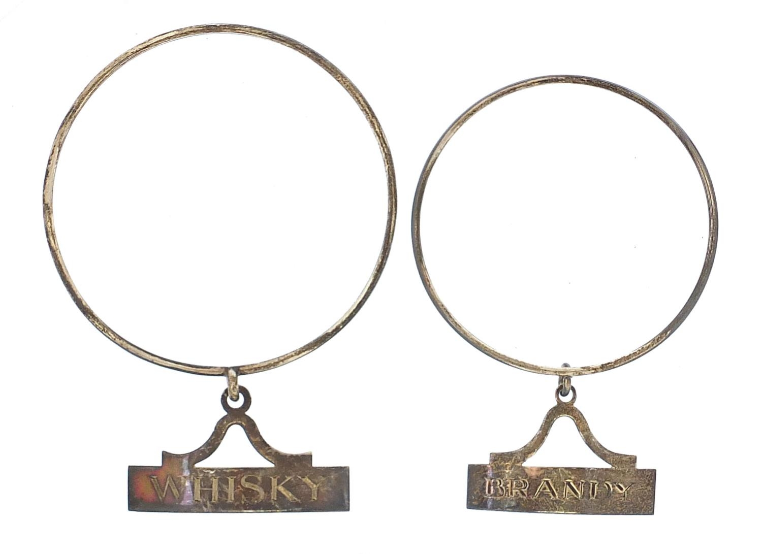 Two silver brandy and whisky decanter labels, London 1978 and 1986, 8.5cm and 7cm in diameter, total