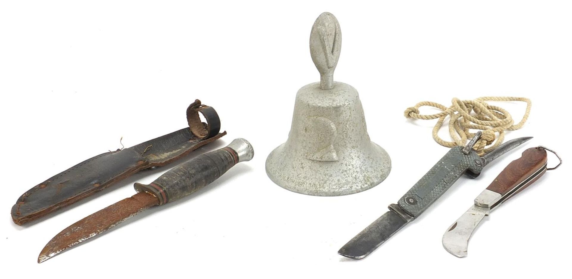 Militaria comprising a bell made from a German aircraft, folding pocket knife and a combat knife,