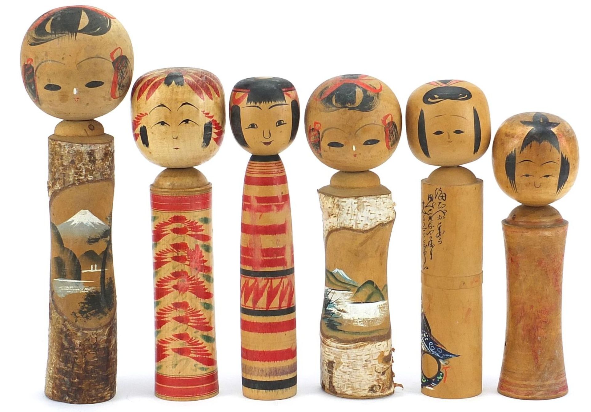 Six Japanese Kokeshi hand painted wood dolls, the largest 29cm high :For Further Condition Reports