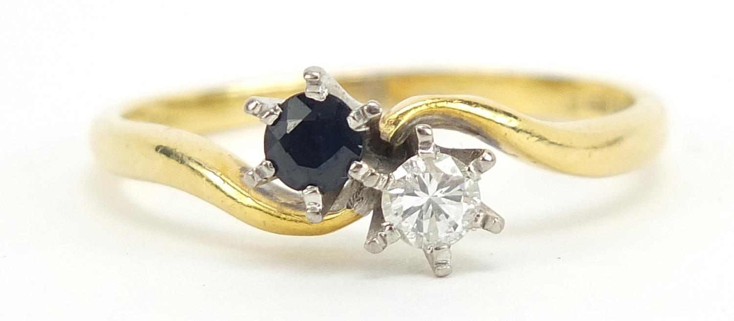 18ct gold diamond and sapphire crossover ring, the diamond approximately 3.5mm in diameter, size