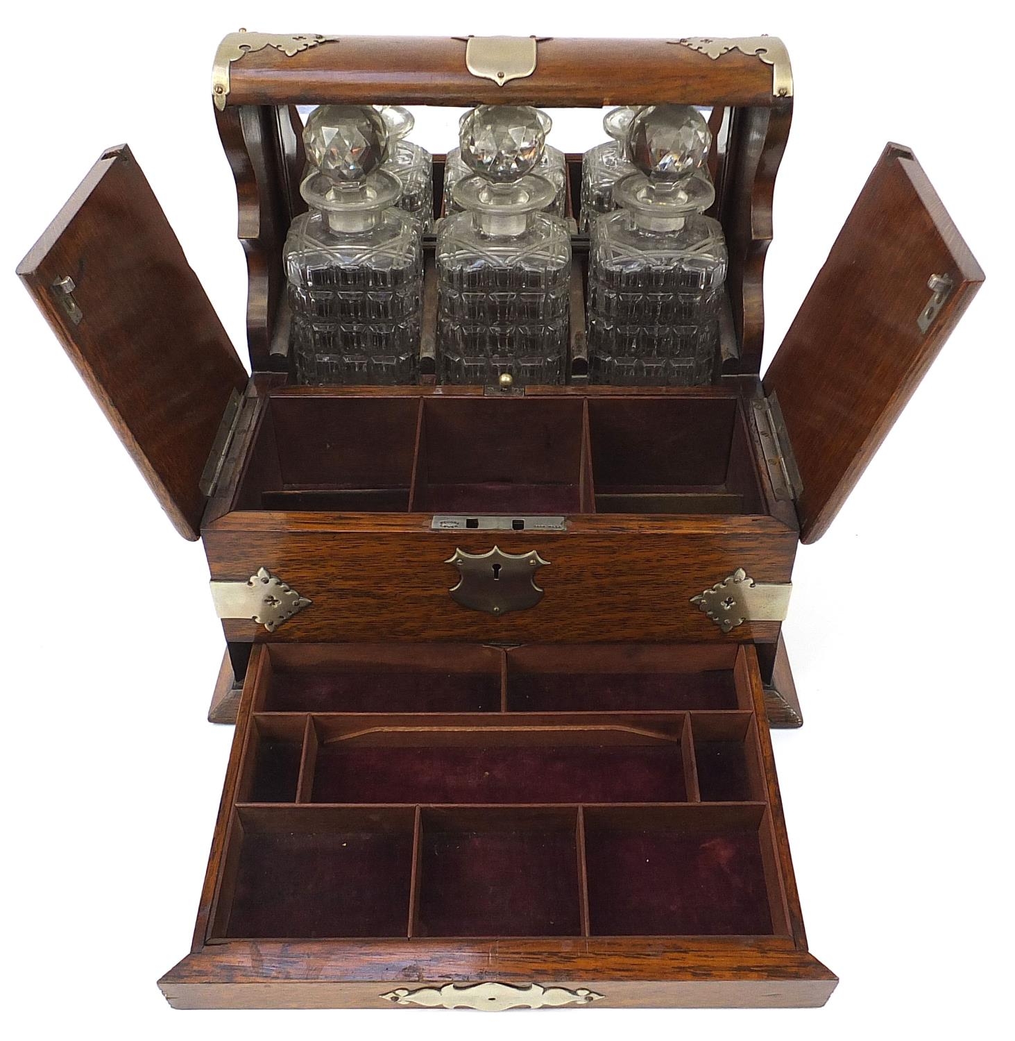 Victorian oak tantalus compendium with metal mounts and carrying handles fitted with three glass - Image 4 of 7