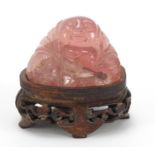 Chinese rose quartz carving of Buddha raised on a carved hardwood stand, 5.5cm wide :For Further