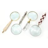 Four large magnifying glasses including one with mother of pearl handle, the largest 26.5cm in