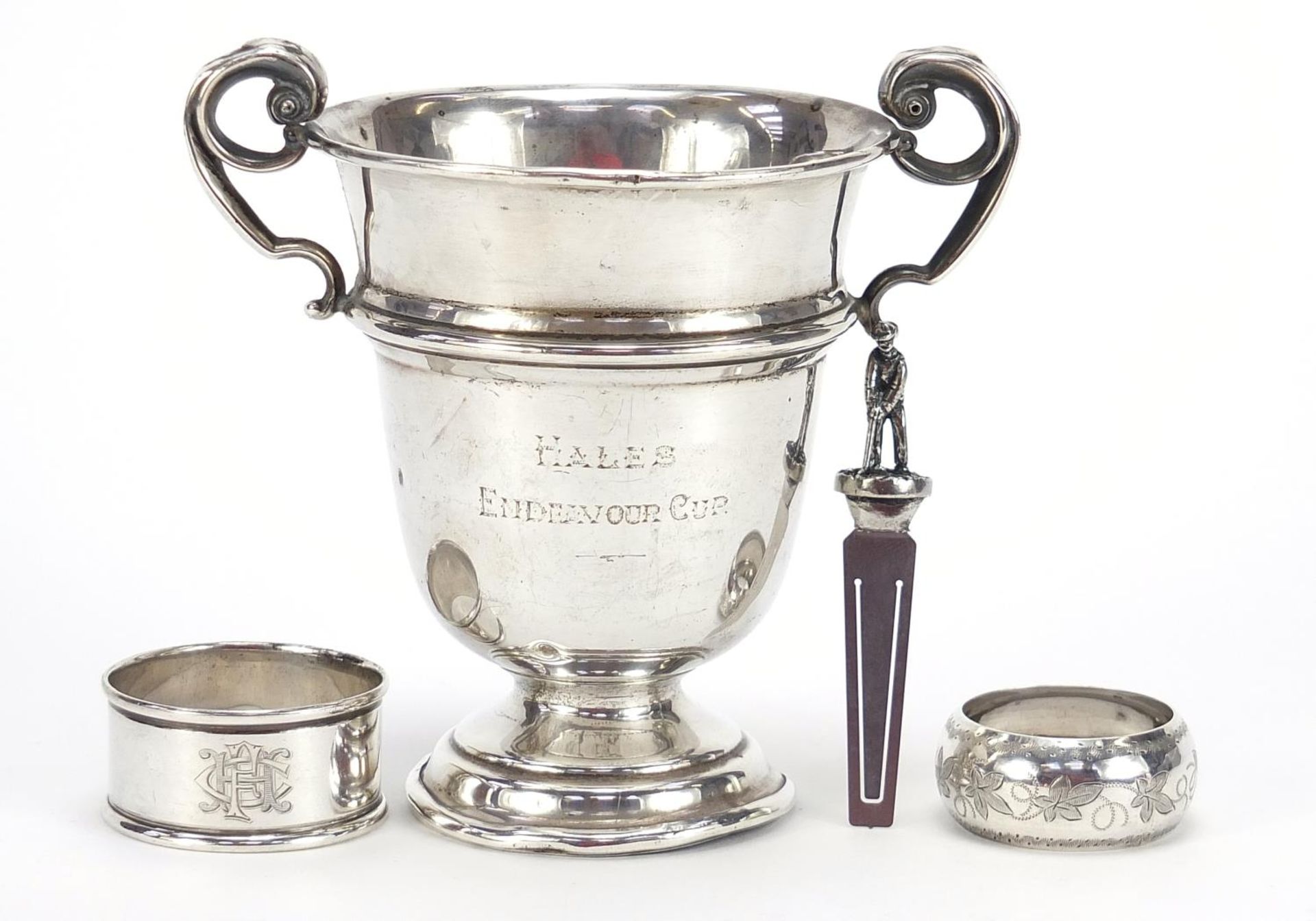 Golfing interest silver trophy with twin handles, two silver napkin rings and a bookmark, the trophy