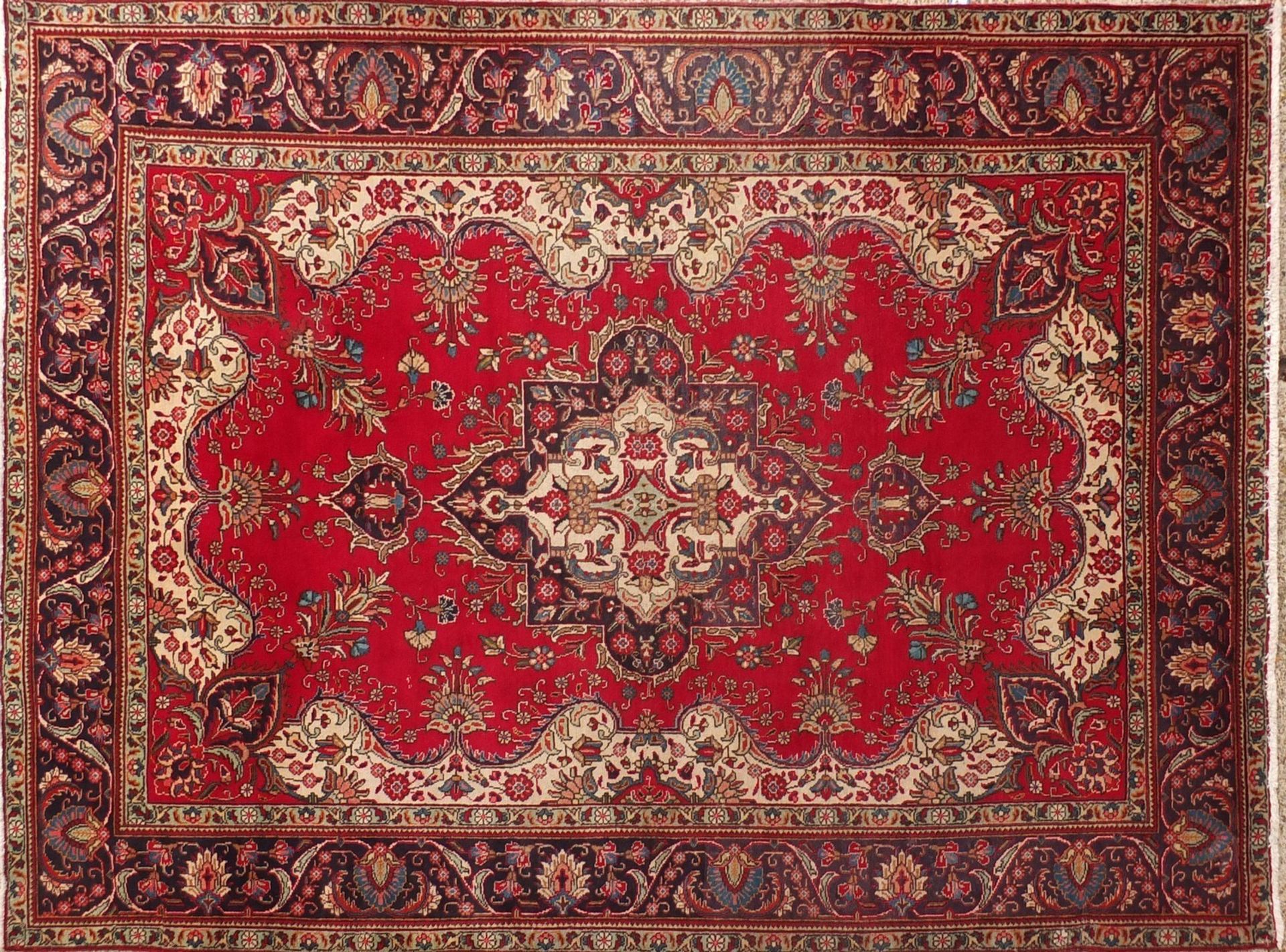 Hand made Iranian carpet with stylised floral pattern onto a red and blue ground, 354cm x 254cm :For