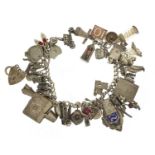 Heavy silver charm bracelet with a large selection of mostly silver charms including bibles, fire