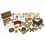 Collection of military interest cap badges and cloth patches together with an Indian brass box :
