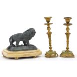 Pair of gilt metal and onyx figural candlesticks and sculpture of a lion, the largest each 17cm high