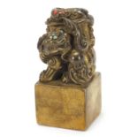 Chinese patinated bronze dog of Foo seal set with turquoise and coral coloured stones, 12cm high :