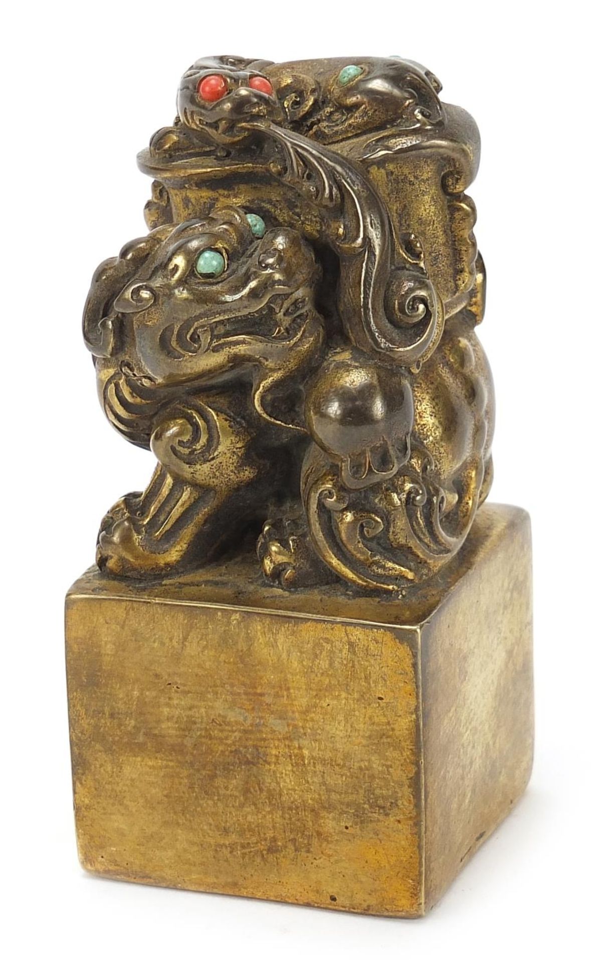 Chinese patinated bronze dog of Foo seal set with turquoise and coral coloured stones, 12cm high :