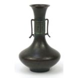 Japanese patinated bronze vase with twin handles, impressed character marks to the base, 21.5cm high