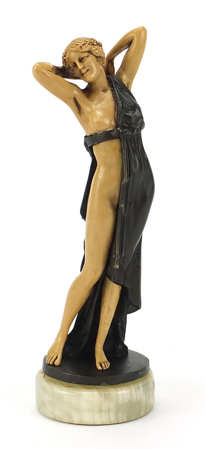 Art Deco style bronzed and ivorine figurine of a scantily dressed female raised on a circular onyx