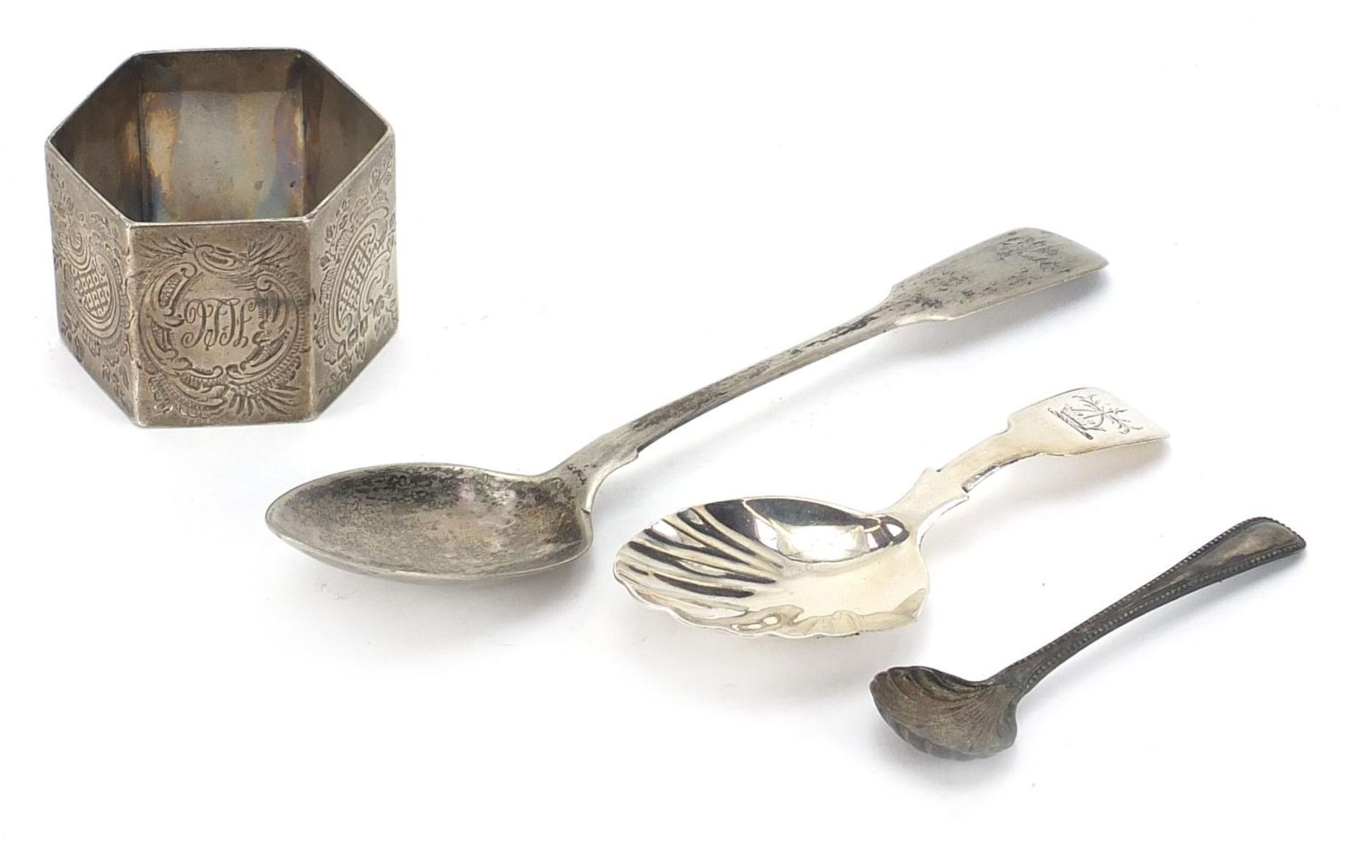 Silver items including a Georgian caddy spoon with shell shaped bowl and a heavy hexagonal napkin