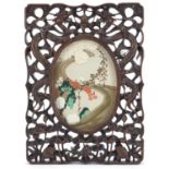 Chinese hardwood frame housing an embroidered panel, the frame deeply carved with two dragons and