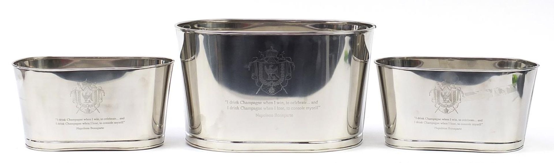 Three Champagne ice buckets with Napoleon Bonaparte and Lily Bollinger mottos, the largest 26cm H