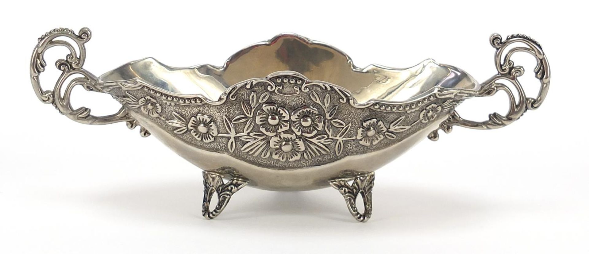 Heavy silver plated twin handled bowl cast with flowers and raised on three feet, 24cm wide :For