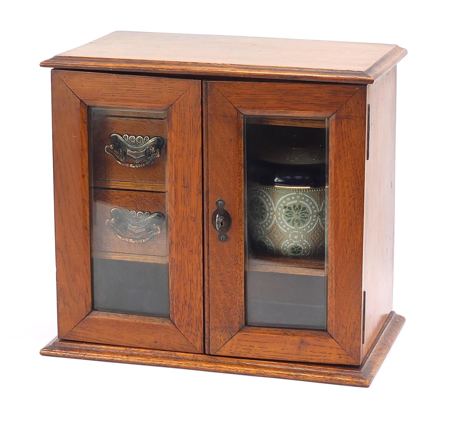 Art Nouveau oak smoker's cabinet with lift up top enclosing a pipe rack, ornate bronzed mounts and