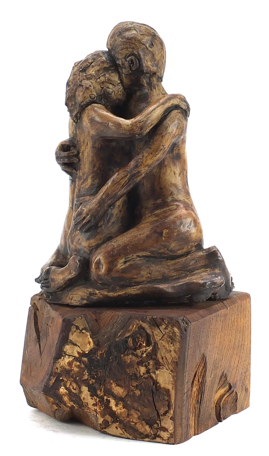 Modernist sculpture of two lovers raised on a naturalistic wood block base, 35cm high :For Further