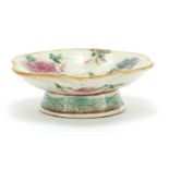 Chinese porcelain footed flower head dish hand painted in the famille rose palette with a bird