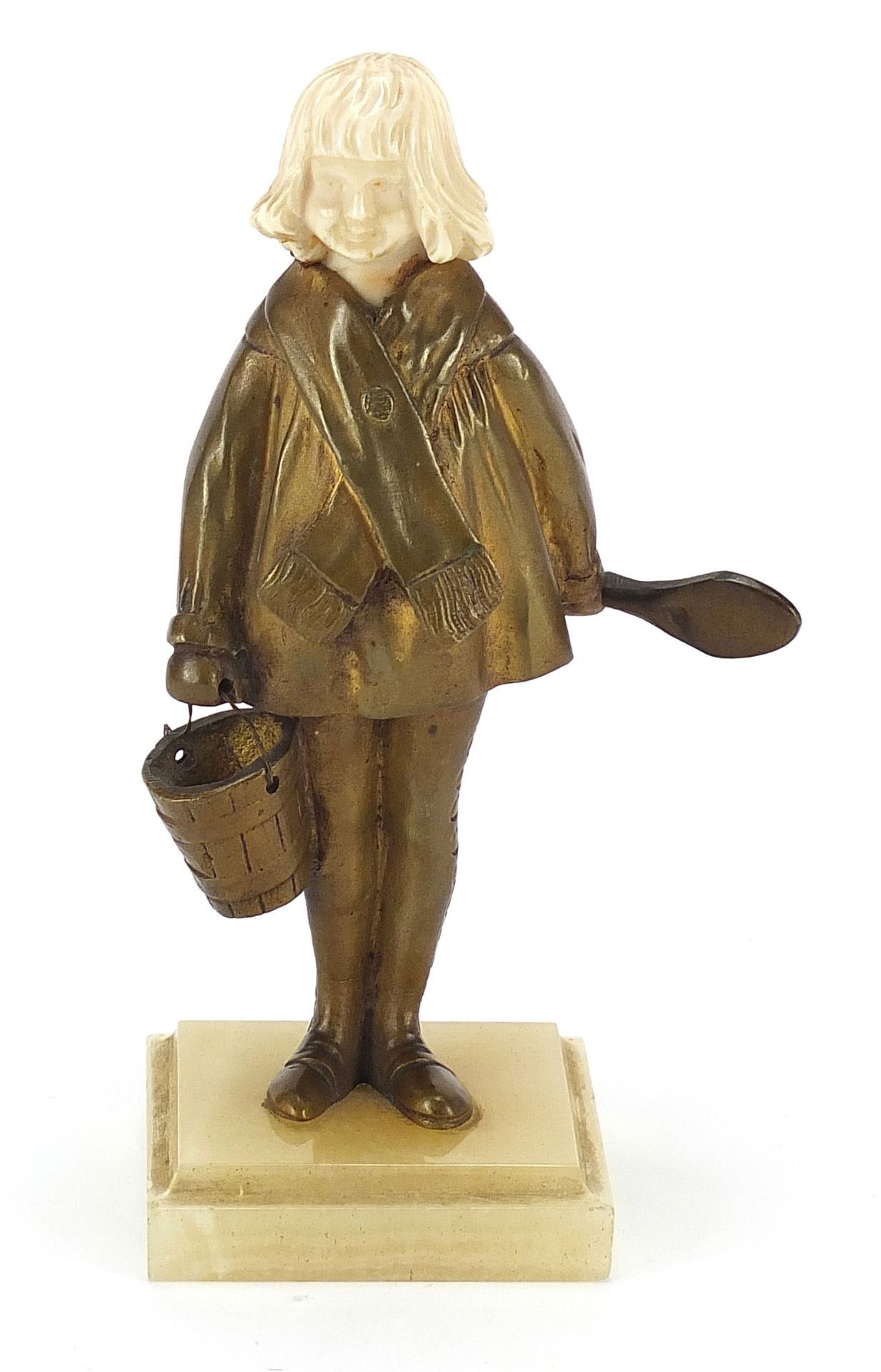 Art Deco gilt bronze and ivory figurine of a young girl holding a spoon and bucket, raised on a