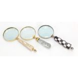 Three magnifying glasses including one with chequered design handle, the largest 25cm in length :