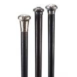 Three ebonised walking sticks with silver pommels, the largest 92cm in length : For Further